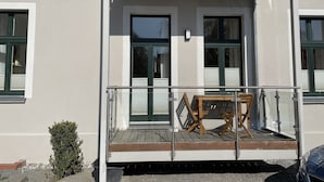 Ein Gebäude mit Balkon, einer Tür und Fenstern.