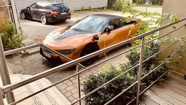 Ein Parkplatz mit einem Sportwagen und einer Limousine.