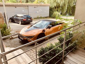 Ein Parkplatz mit einem Sportwagen und einer Limousine.