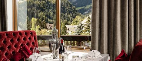 A dining table set for a meal with a view of a mountainous landscape.