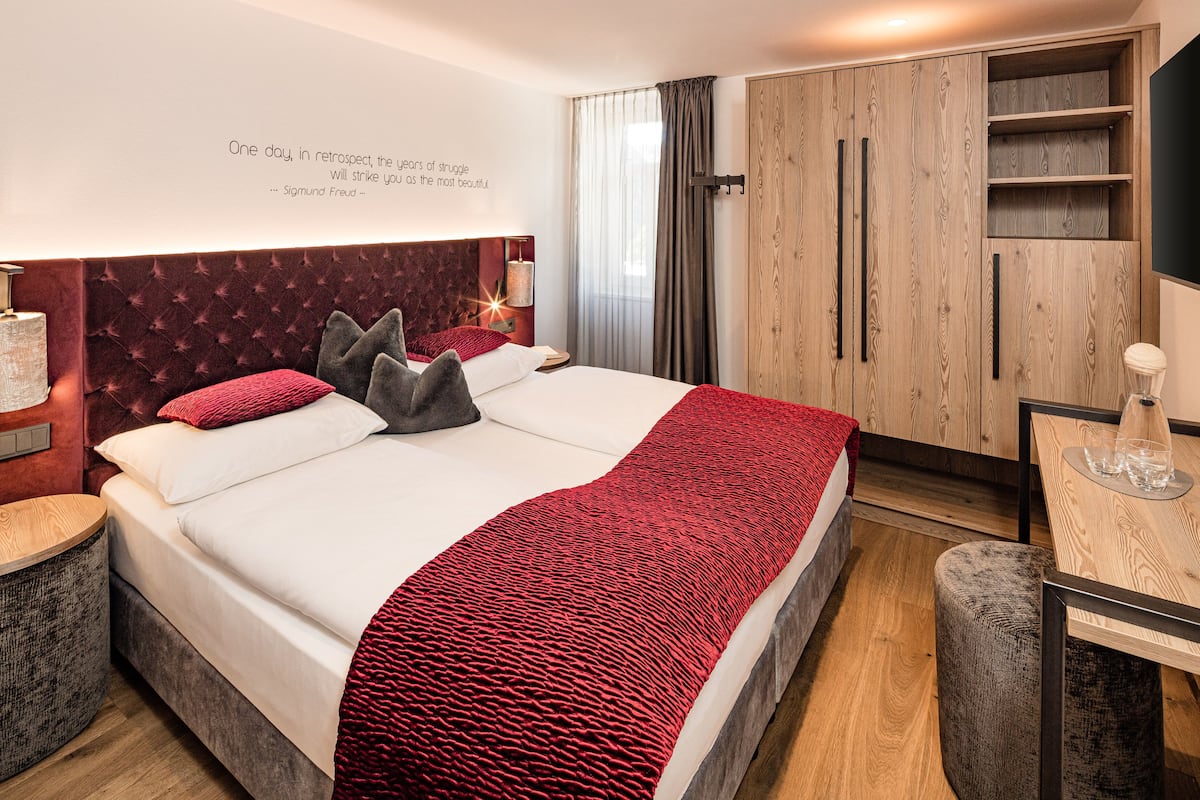 Et moderne hotelværelse med en stor seng, et skrivebord og et klædeskab.