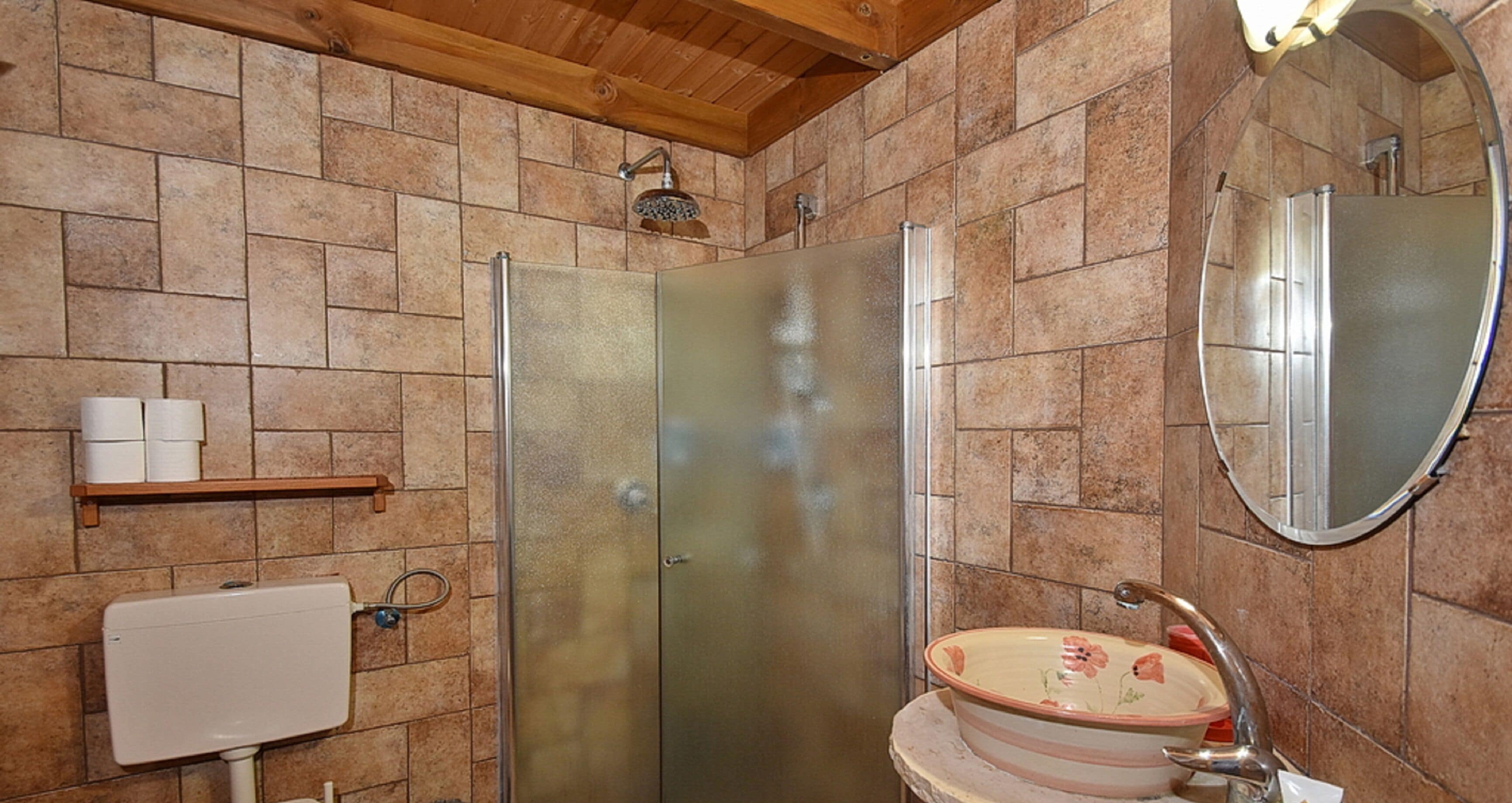 A bathroom with a toilet, shower, and sink.