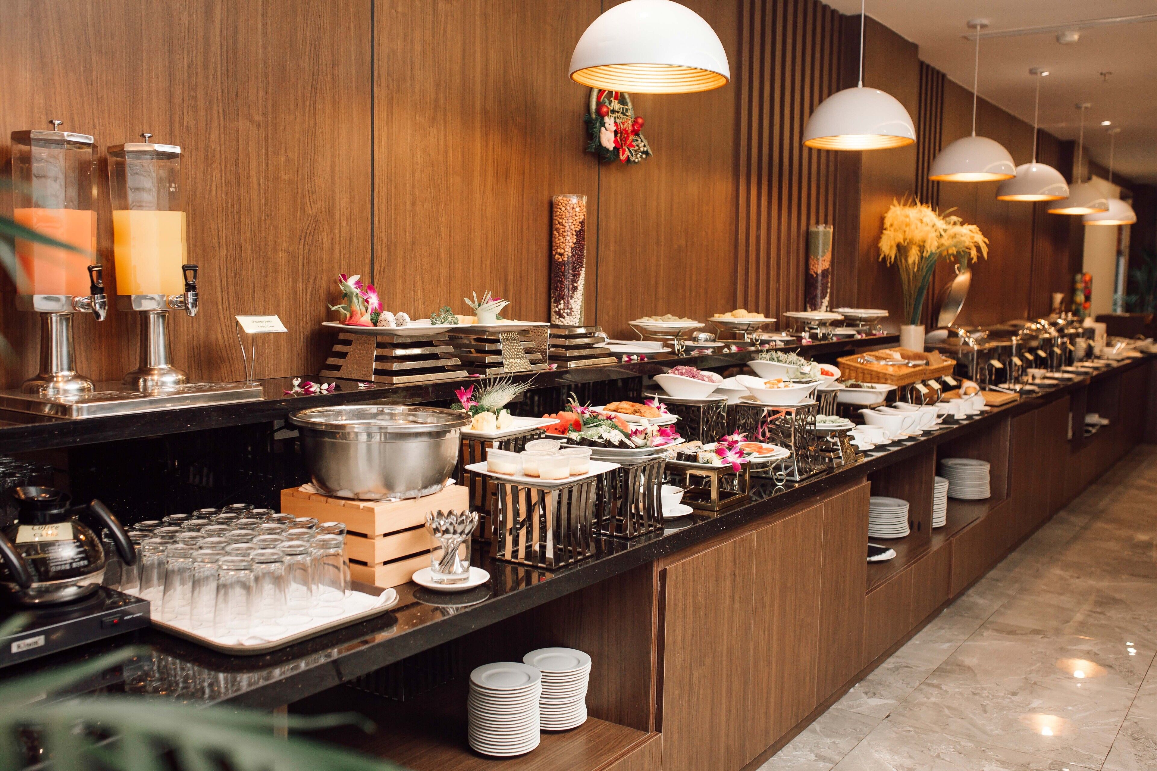 A buffet setup with various food items and drink dispensers.