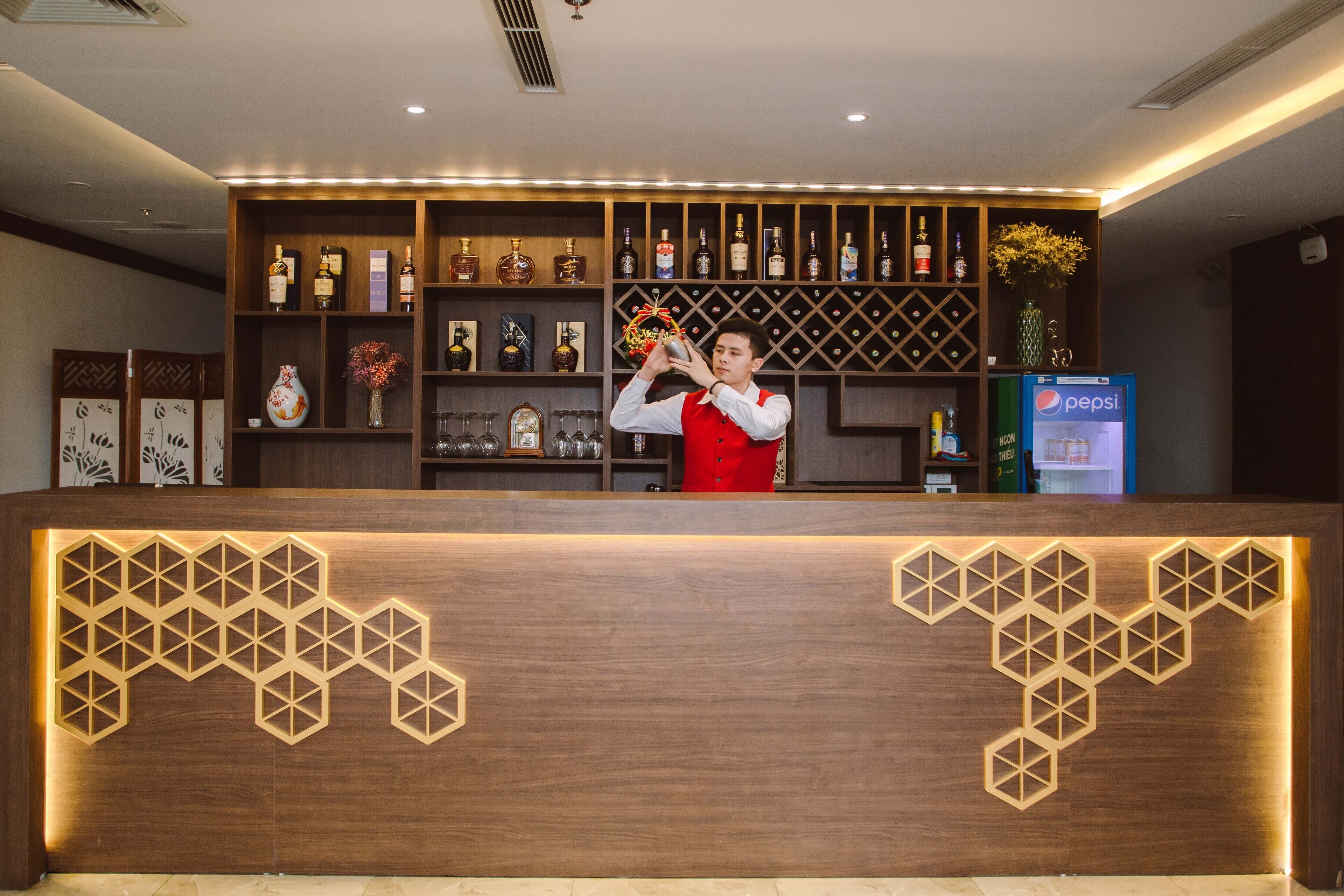 A bar area with a wooden counter, shelves with bottles, and a Pepsi refrigerator.