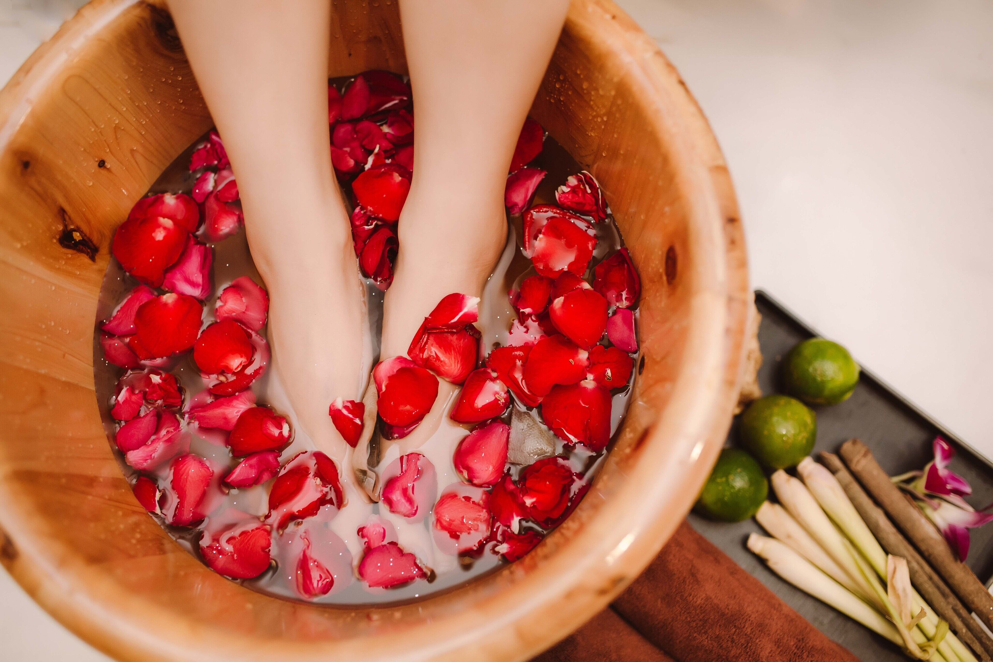 A wooden basin filled with water and rose petals.