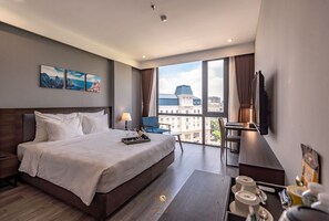 Una habitación de hotel moderna con una cama grande, un escritorio, una silla y un televisor.