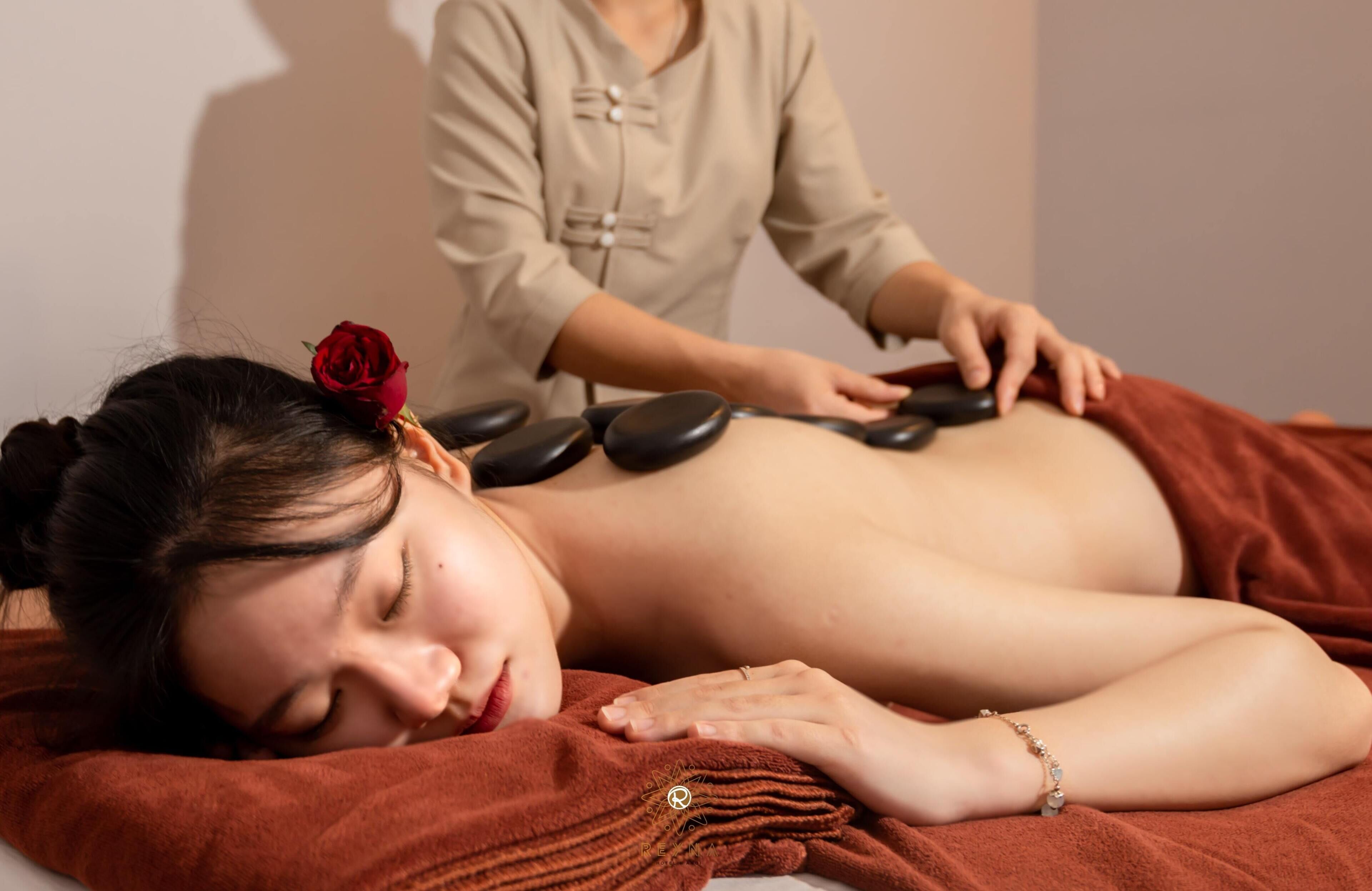 Une personne recevant un massage du dos sur une table de massage, avec un thérapeute.