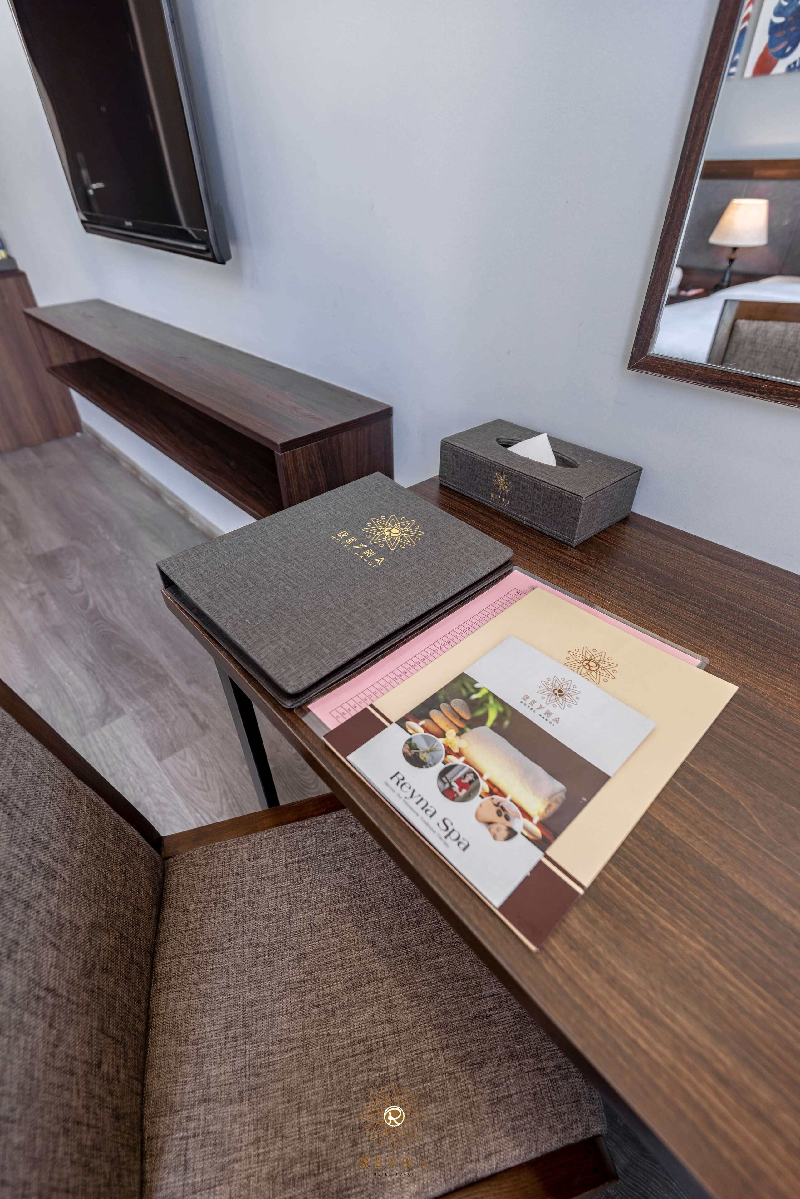 A neatly arranged desk with a book, a tissue box, and a brochure.