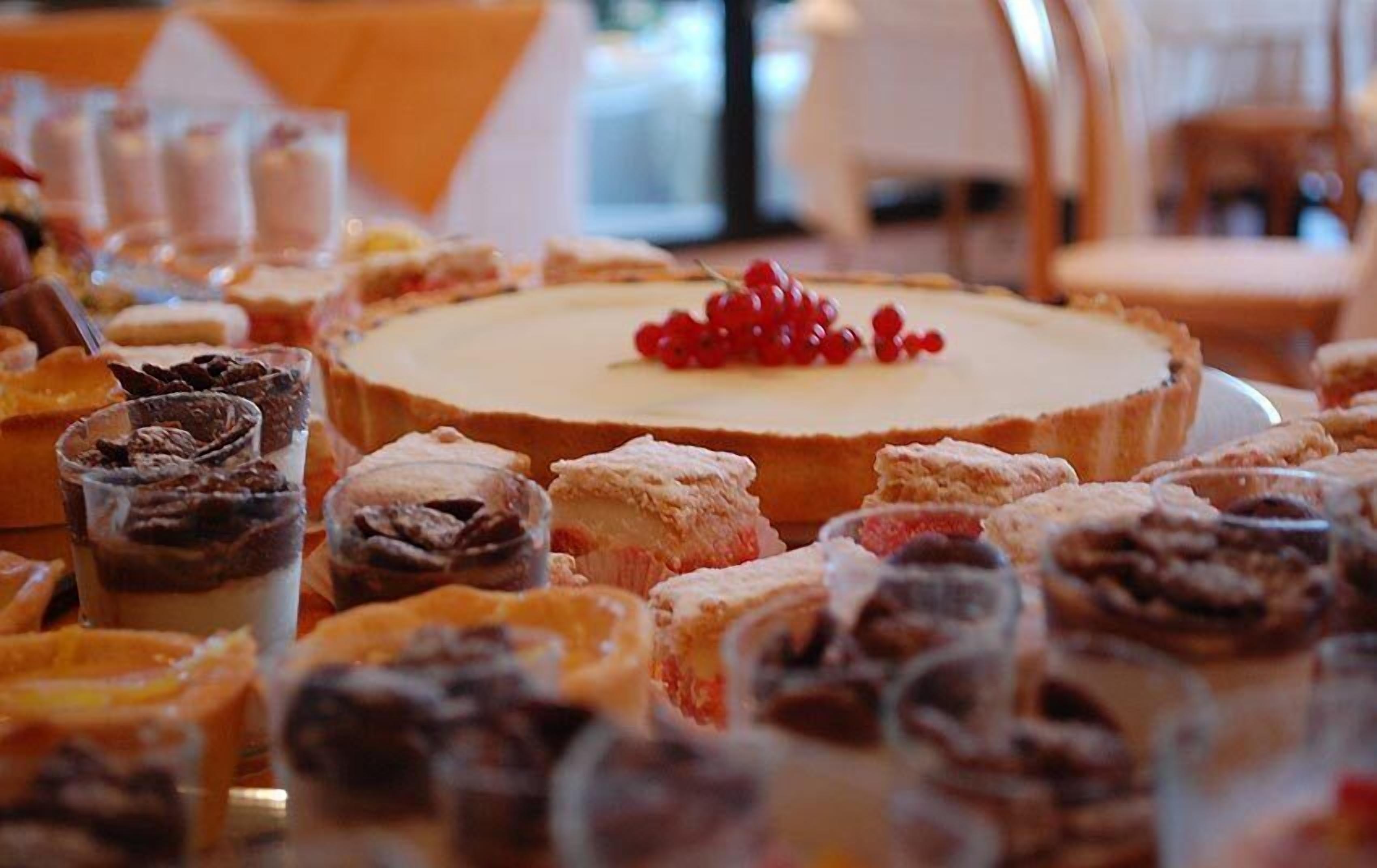 Una mesa de postres con diversos pasteles y un pastel.