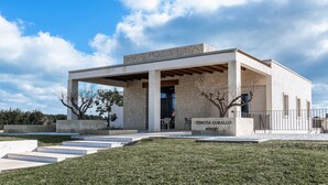 A modern building with a stone facade, named "Tenuta Corallo Winery."