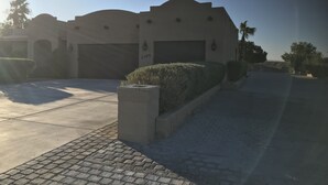 A residential building with a garage, a driveway, and a well-maintained hedge. - Guitar Shaped Pool ! (Bullhead City)