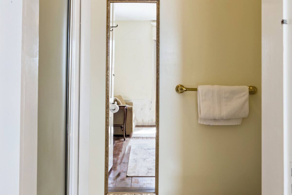A bathroom with a toilet, a towel rack, and a mirror.