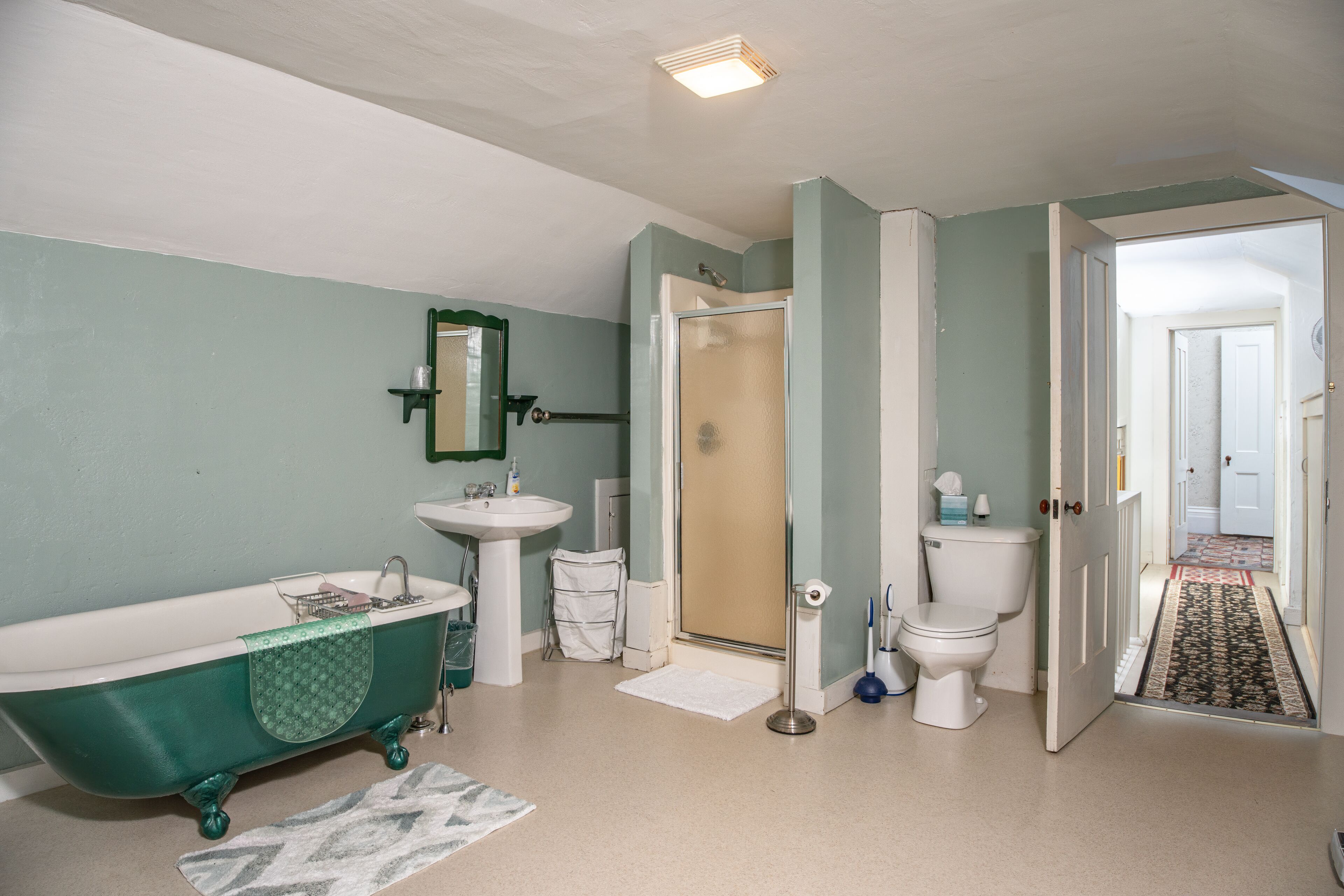 A bathroom with a freestanding bathtub, a sink, a toilet, and a shower stall.