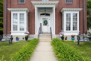 A brick building with a white entrance, steps leading up to a door, and potted plants on either side. - The Jeremiah Mason House B & B (Limerick)