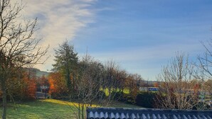 A residential area with a tiled roof, a grassy yard, and trees with autumn foliage. - Golden Dawn Guesthouse (Saggart)