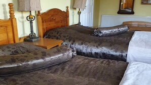 A double bed with floral-patterned bedding, a wooden headboard, and two bedside lamps. - Golden Dawn Guesthouse (Saggart)