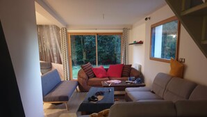Un salon avec un canapé, une table basse et un chien.