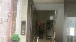 A hotel entrance with a stone facade, a blue planter with a small plant, and a staircase leading inside. - Hotel Garni Frankfurt (Frankfurt)