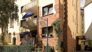 A multi-story building with a balcony on the second floor. - Hotel Garni Frankfurt (Frankfurt)