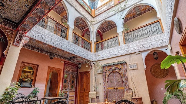 A courtyard with ornate arches, a fountain, and a seating area with chairs and tables. - Riad Villa Sidi Baba (Marrakech)