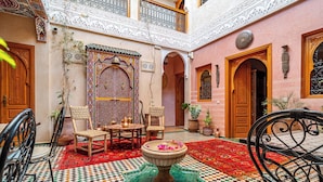 A traditional Moroccan interior with ornate doors, a tiled courtyard, and a central fountain. - Riad Villa Sidi Baba (Marrakech)