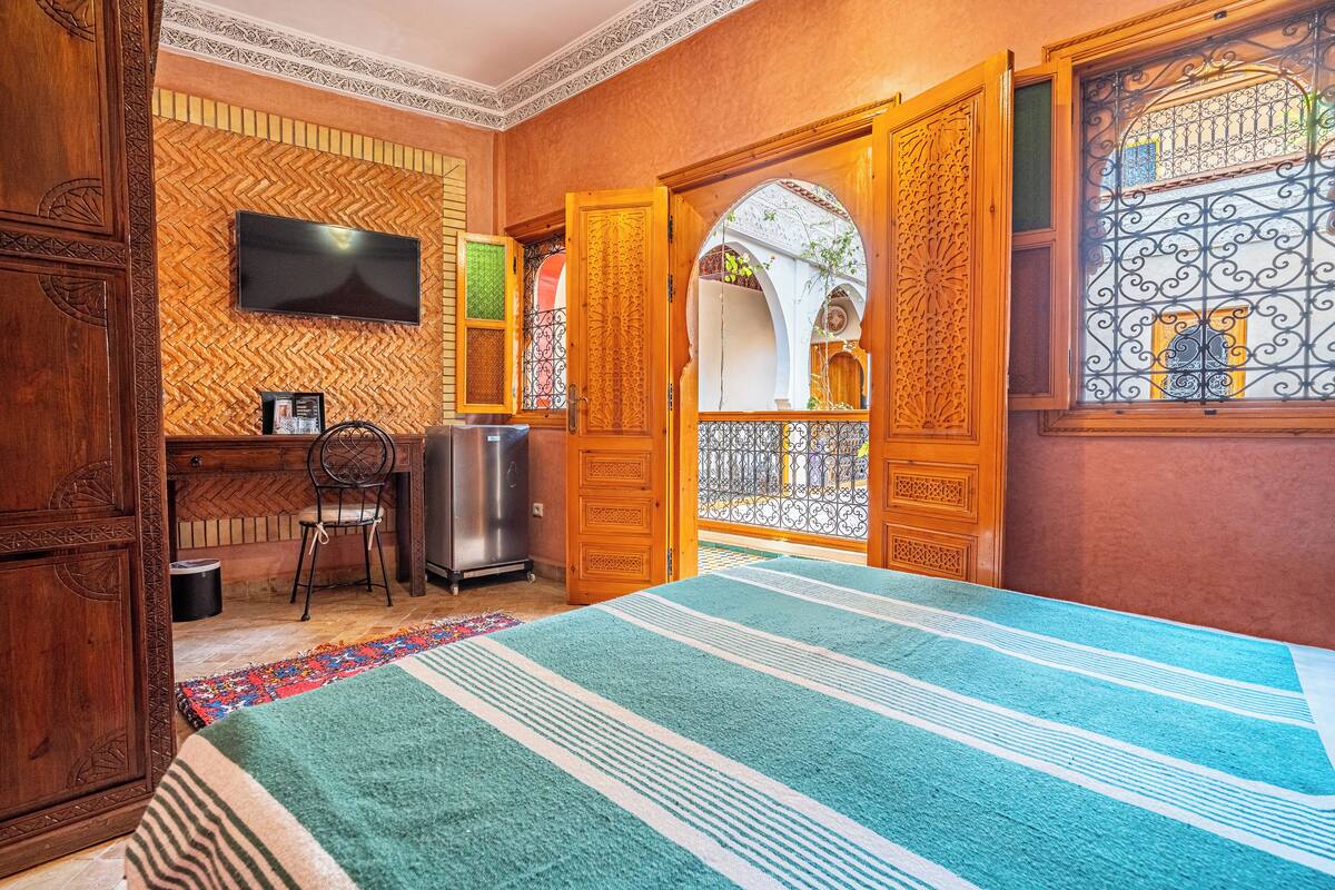 Une chambre avec un lit, une télévision, un bureau et une chaise.