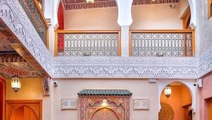 A traditional Moroccan interior with a checkered floor, ornate doors, and a courtyard with seating and a fountain. - Riad Villa Sidi Baba (Marrakech)