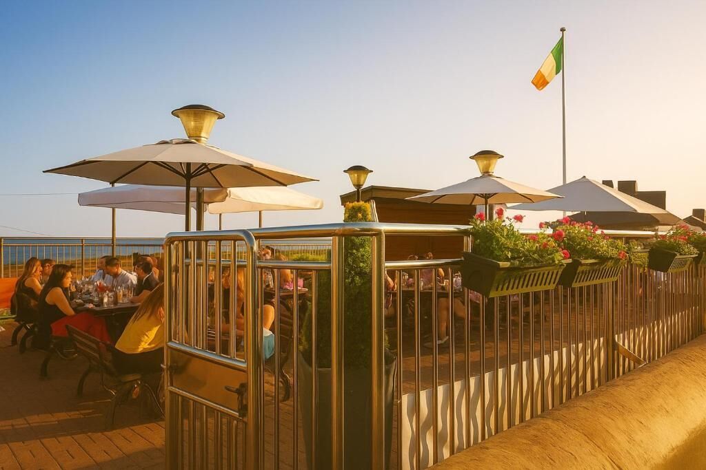 An outdoor dining area with tables and chairs, umbrellas, and a railing.