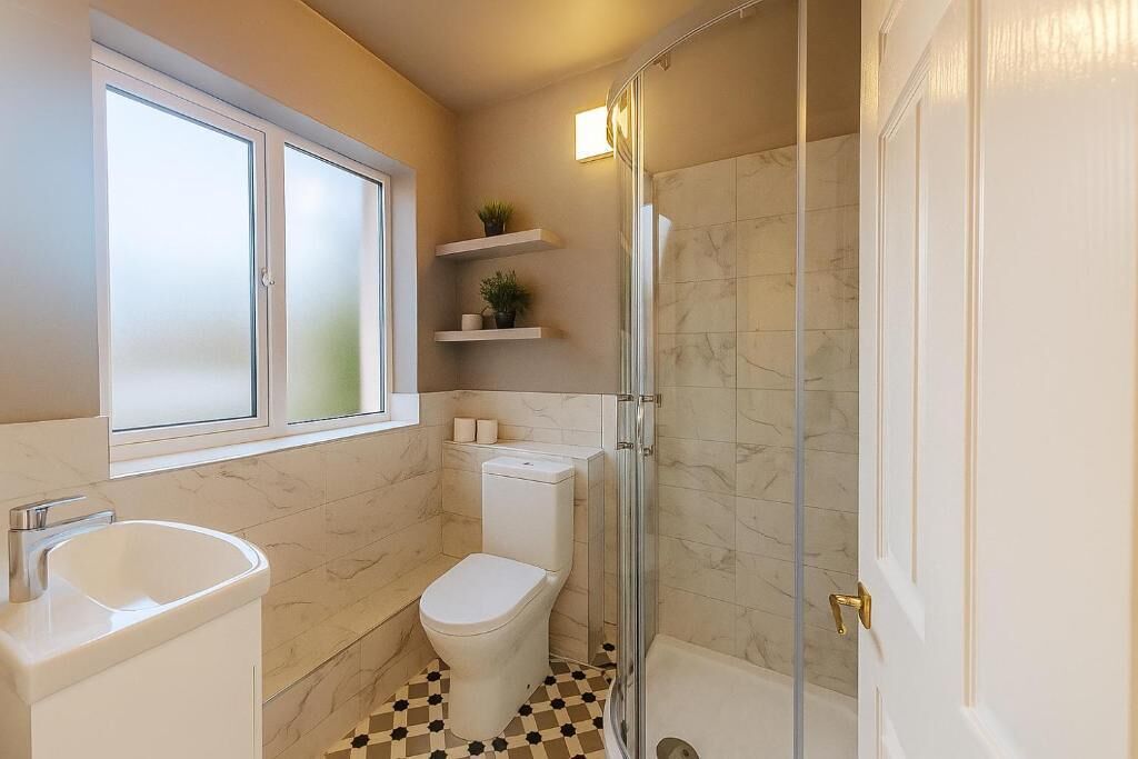 A bathroom with a toilet, sink, and shower. There are shelves with plants and a window above the toilet.
