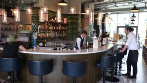 A bar area with a counter, stools, and hanging lights. - London Islandic One Excel - O2 - Parking (London)