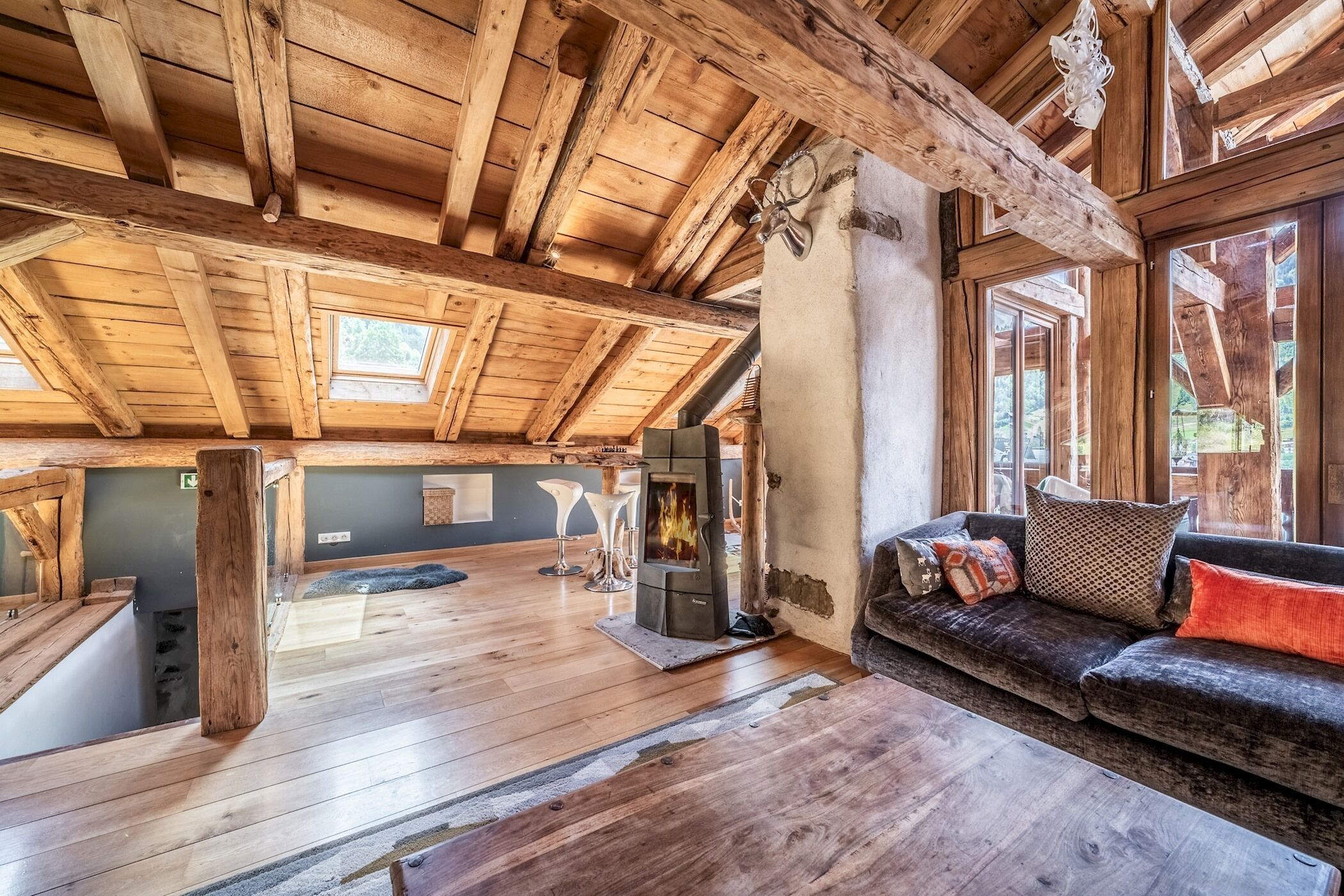 Un interior de madera espacioso con un techo alto, un sofá acogedor y una chimenea.