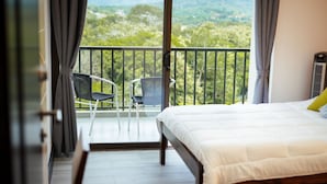 Un dormitorio con balcón, una cama y dos sillas.