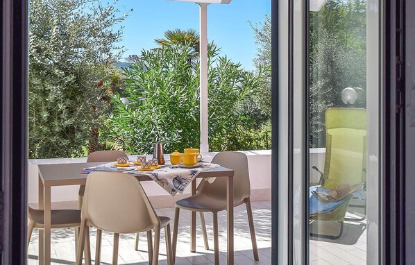 An outdoor dining area with a table set for two, chairs, and a yellow cup. - Nice home in Castellabate with house a panoramic view (Castellabate)