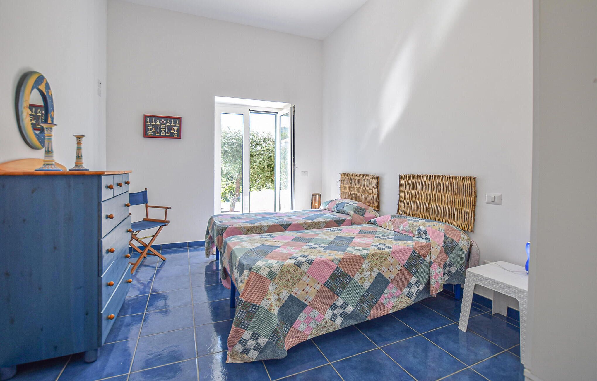 Une chambre avec deux lits, une commode et une chaise.
