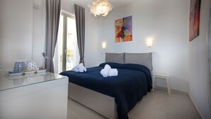 A modern bedroom with a bed, bedside tables, a glass dresser, and a view of the outside. - Casa Don Micio (Taormina)
