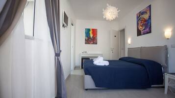 Une chambre d’hôtel moderne avec un grand lit, un bureau et un tableau au mur.