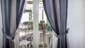 A balcony with a white chair and potted plants. - Casa Don Micio (Taormina)