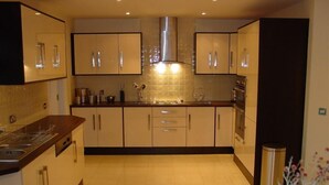 Una cocina moderna con una isla central, electrodomésticos de acero inoxidable y un salpicadero de azulejos.