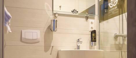 A modern bathroom with a toilet, sink, and glass shower enclosure.
