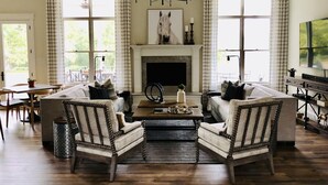 A spacious living room with a fireplace, two sofas, a coffee table, and a TV. - The Farmhouse (Hammonton)