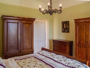 A bedroom with a bed, wooden wardrobe, and a dresser. - Kill House (Clifden)