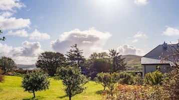 A grassy landscape with trees and a building.