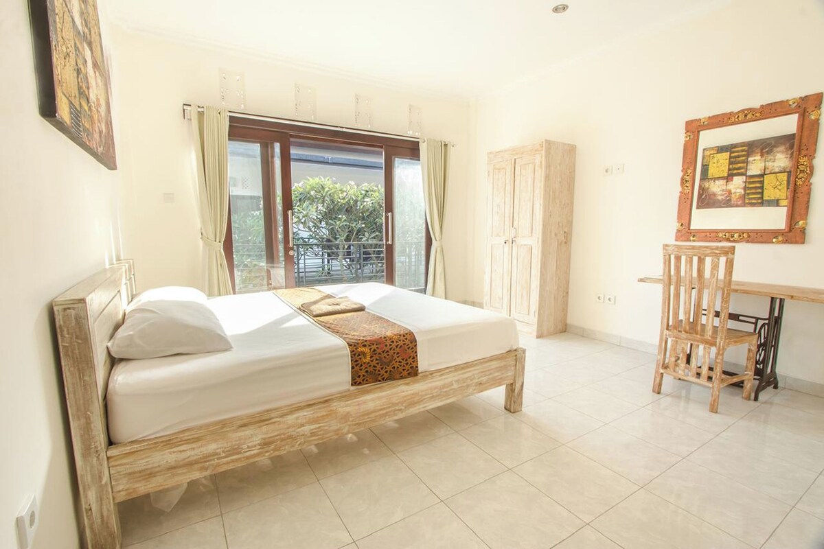 A bedroom with a bed, a desk, and a chair.