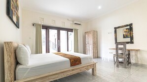 A bedroom with a wooden bed, a desk, and a chair. - Azalea Homestay & Villa (Canggu)