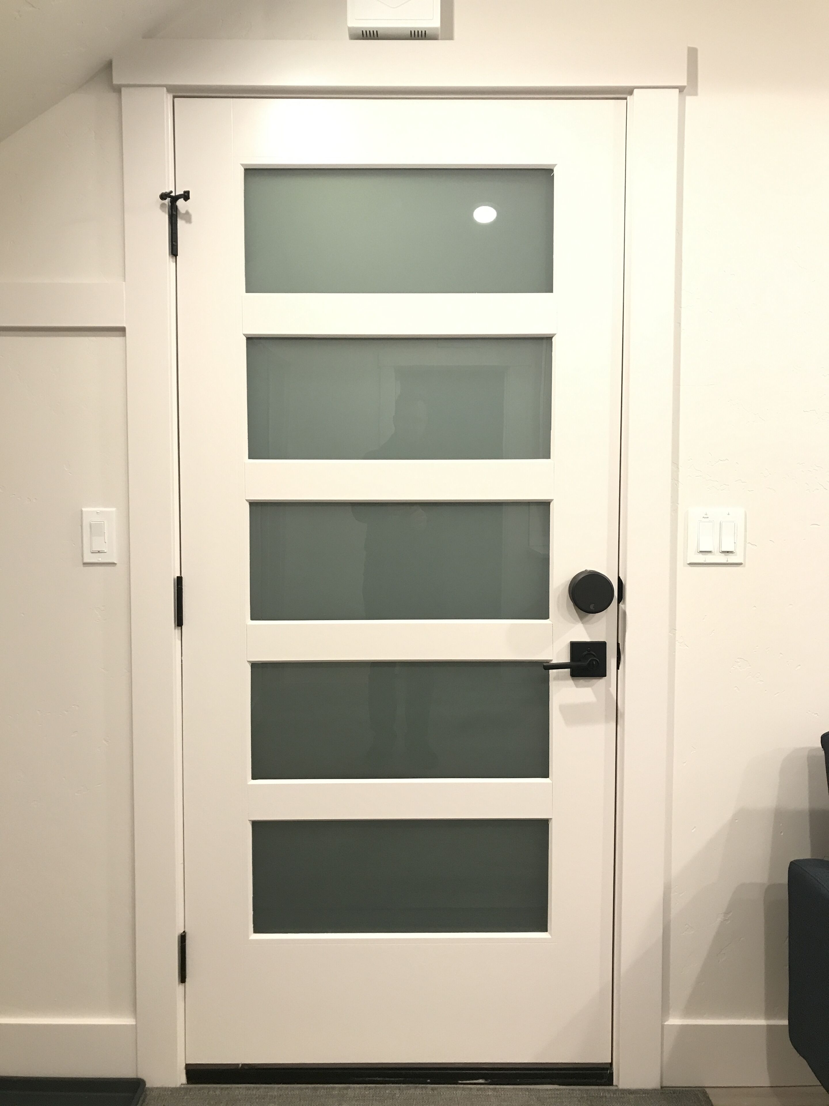 A white door with a frosted glass panel and a modern handle.