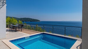 A swimming pool with a view of the sea and a hilly landscape. - Awesome home in Smokvica (Smokvica)