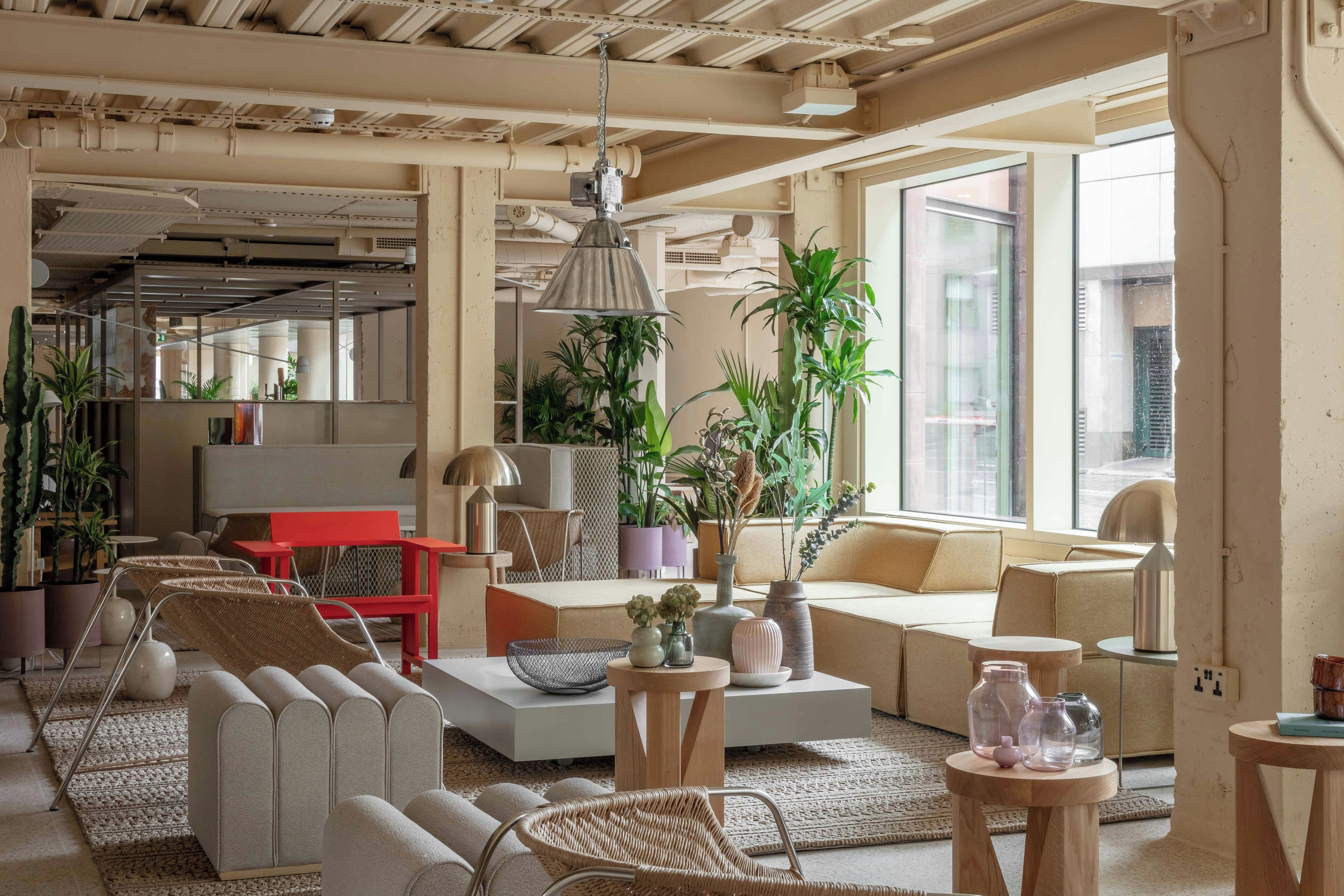 Un salon moderne avec un canapé, des fauteuils, une table basse et des plantes en pot.