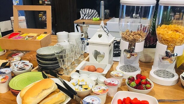 A buffet table with various food items, including bread, eggs, yogurt, strawberries, and red kidney beans. - B&B MonteCengio (Trieste)