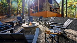 A lodge with a stone fireplace, outdoor seating, and a wooden deck.