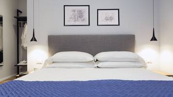 Een hotelkamer met een groot bed, een hoofdbord, twee ingelijste kunstwerken aan de muur en bedlampen.
